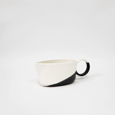 Caneca de cerâmica branca e preta com padrão texturizado e pega redonda