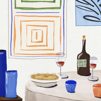 Mesa com comida, copos e garrafa, quadros geométricos na parede