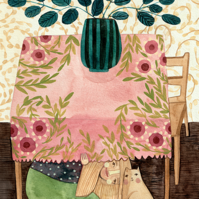 Mesa com toalha floral, vaso com folhas, criança e gato escondidos embaixo.