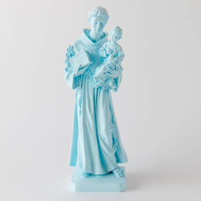 Estátua azul clara de figura religiosa masculina com criança e livro