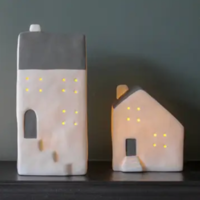 Luminárias em forma de casas com luzes nas janelas