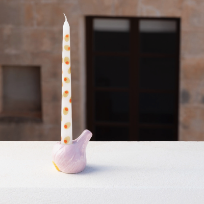 Castical cerâmico rosa com vela branca decorada com círculos amarelos e laranja