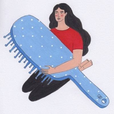 Mulher a segurar escova de cabelo azul clara com pontos brancos