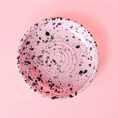 Prato redondo rosa com manchas pretas e textura espiral
