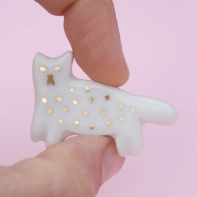 Figura de gato em cerâmica branca com pontos dourados