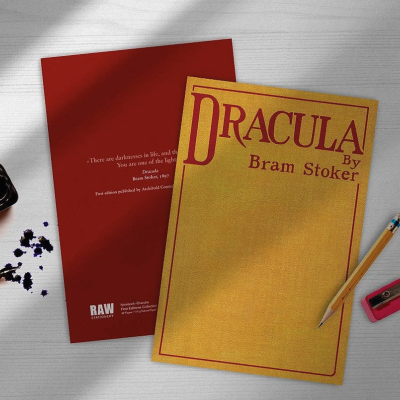 Cadernos Dracula junto a acessórios de escrita sobre mesa branca