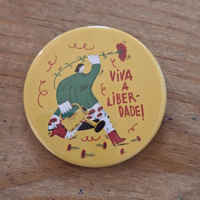 Botão redondo amarelo com ilustração e texto 'VIVA A LIBER-DADE!'