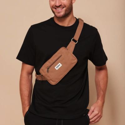 Homem com t-shirt preta e pochete castanha cruzada no peito