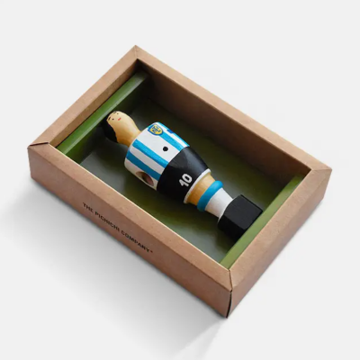 Boneco de jogador de futebol de madeira numa caixa de cartão