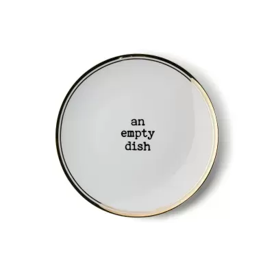 Prato branco redondo com borda dourada e frase 'an empty dish' no centro
