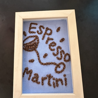 Quadro decorativo com arte em fio castanho e texto Espresso Martini