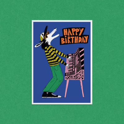 Cartão de aniversário ilustrado com lobo a tocar teclado e texto HAPPY BIRTHDAY