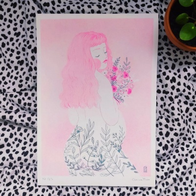 Desenho de mulher com cabelo rosa e flores, em papel, sobre tecido branco com manchas pretas