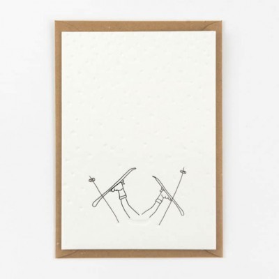 Cartão branco com desenho minimalista de pernas com botas e esquis cruzados