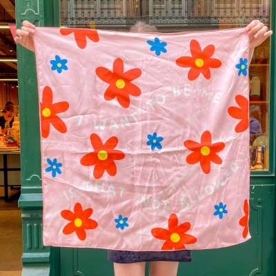 Lenço quadrado rosa com flores vermelhas e azuis e texto branco