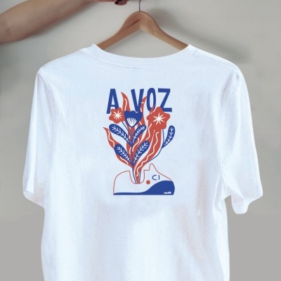 T-shirt branca com estampa colorida e a palavra 'A VOZ' nas costas