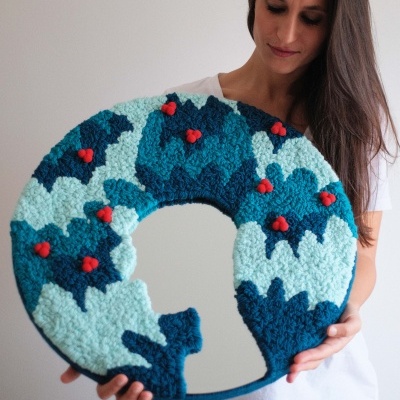 Almofada redonda azul com padrão e corações vermelhos, sombra de gato, segurada por mulher