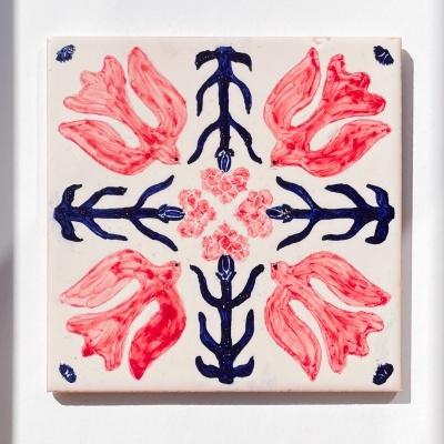 Azulejo quadrado com padrão floral vermelho e azul sobre fundo branco