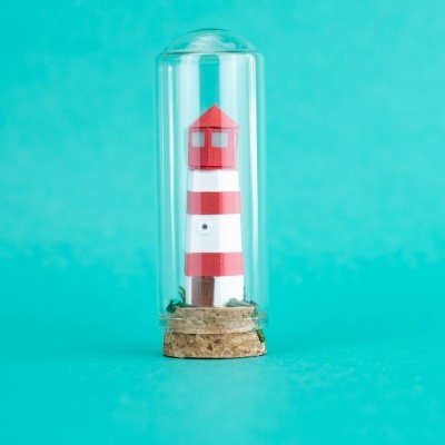 Mini farol vermelho e branco dentro de frasco de vidro com tampa de cortiça