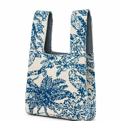 Mala de tecido com padrão azul e branco, alças largas e padrão botânico.