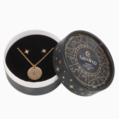 Conjunto de brincos e colar dourados com tema astrológico em caixa preta redonda