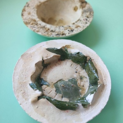 Dois recipientes redondos de material natural sobre fundo azul claro