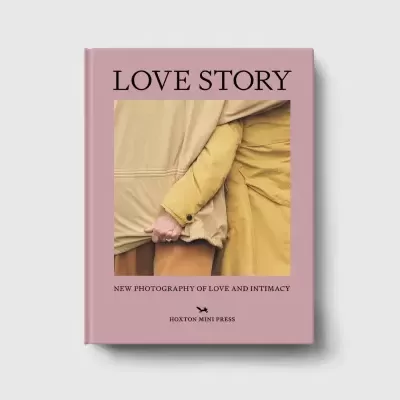 Livro rosa com título LOVE STORY e foto de duas pessoas de casacos bege e amarelo a dar as mãos