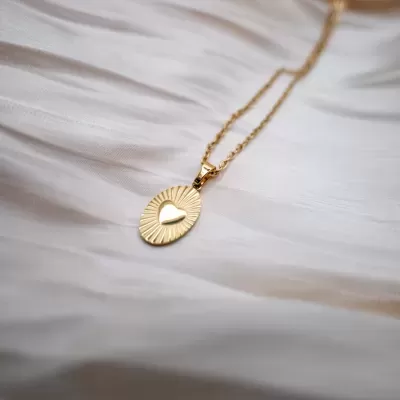Colar dourado com pendente oval e coração central em relevo