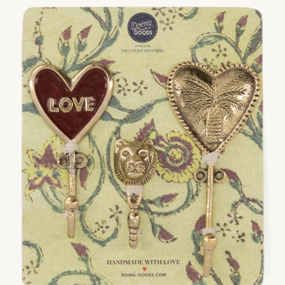 Conjunto de três ganchos metálicos dourados em cartão floral, um com coração vermelho e texto LOVE.