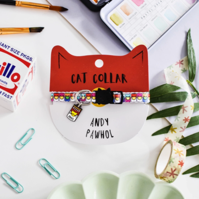 Colar colorido para gato com padrão de latas de sopa e embalagem com texto 'CAT COLLAR' e 'ANDY PAWHOL'