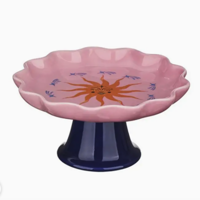 Prato de cerâmica rosa com sol laranja desenhado e base azul escura