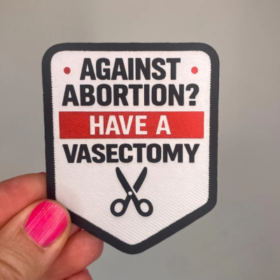 Adesivo tecido com texto contra o aborto e ilustração de tesoura