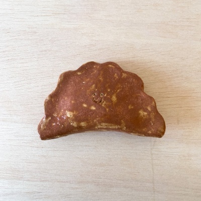 Croissant pequeno com rosto sorridente desenhado com furos