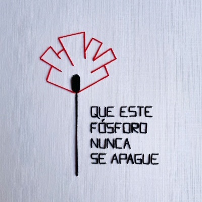 Bordado de um fósforo com texto 'QUE ESTE FÓSFORO NUNCA SE APAGUE' em tela branca