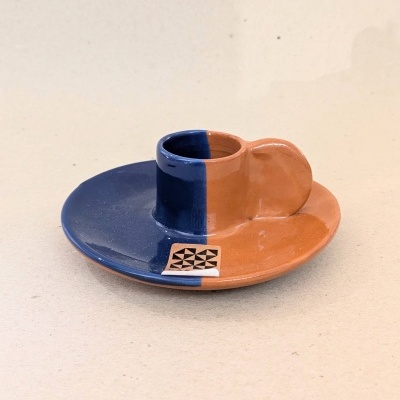 Castiçal cerâmico azul e laranja com padrão geométrico