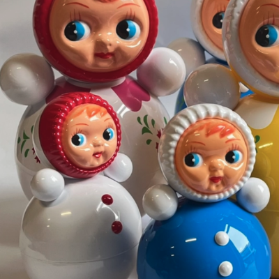 Bonecos redondos coloridos de plástico com faces pintadas e corpos em branco, azul e amarelo