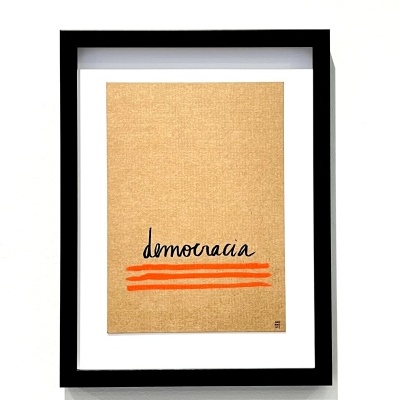 Quadro com placa castanha e texto democracia com linhas vermelhas, moldura preta