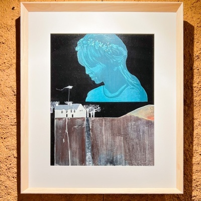 Pintura em quadro com figura feminina azul e casa branca, pendurada em parede laranja.