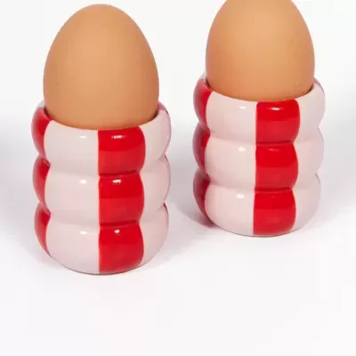 Duas bases para ovos cerâmicas vermelho e branco com ovos castanhos
