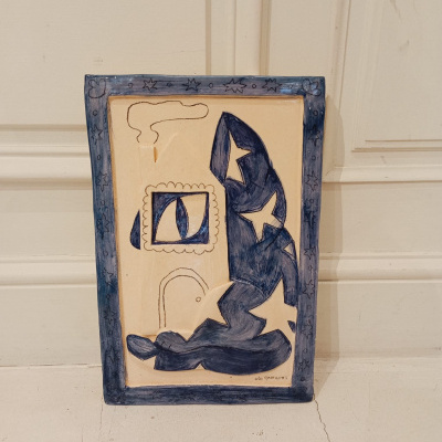 Placa decorativa em cerâmica com padrão abstrato azul e bege com borda azul estrelada.