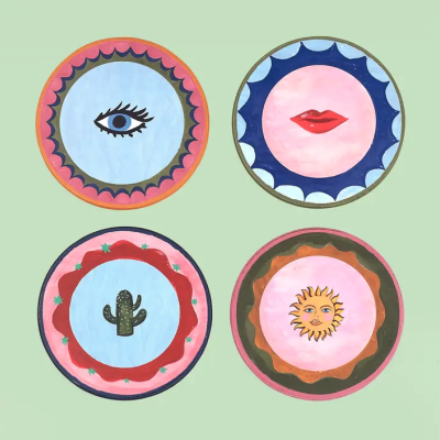 Quatro pratos decorativos redondos com desenhos de olho, lábios, cacto e sol