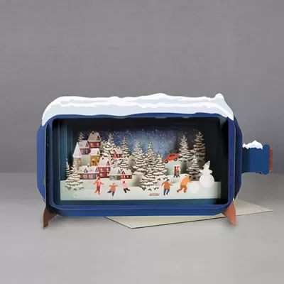 Miniatura decorativa de inverno numa caixa azul com neve artificial no topo