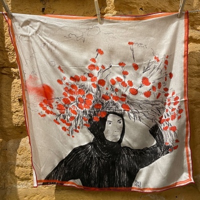 Lenço branco com desenho de mulher e flores vermelhas, pendurado na parede