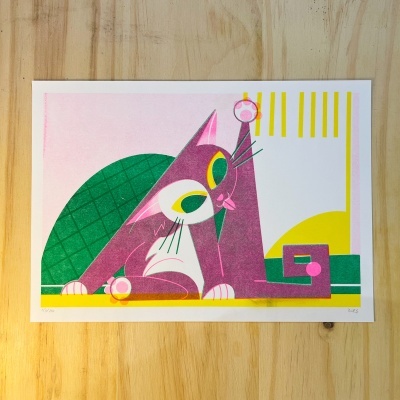 Poster ilustrado colorido de gato estilizado em papel sobre madeira.