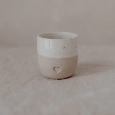 Copo cerâmico duplo branco e bege com coração gravado.
