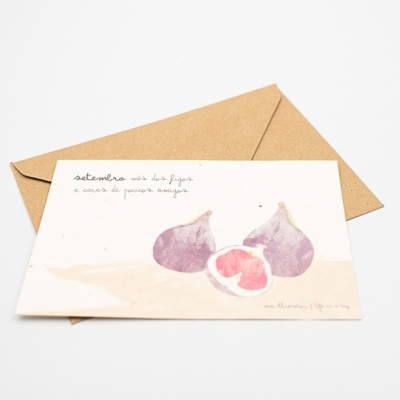 Cartão com ilustração de figos e texto em português ao lado de um envelope castanho.