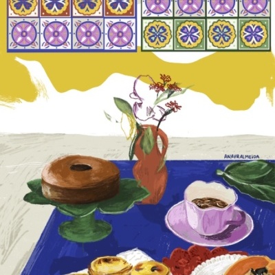 Mesa com doces, chávena lilás, flores num jarro e azulejos decorativos na parede.