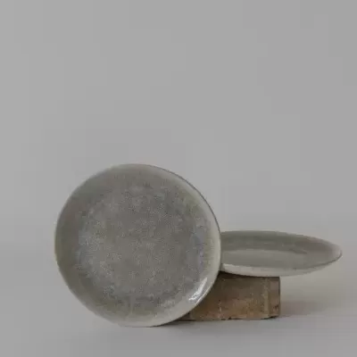 dois pratos cerâmicos cinzentos sobre fundo neutro