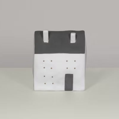 Produto decorativo em forma de casa branco e cinza com telhado e chaminés