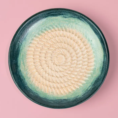 Prato cerâmico redondo com padrão em espiral creme e bordas verdes e azuis